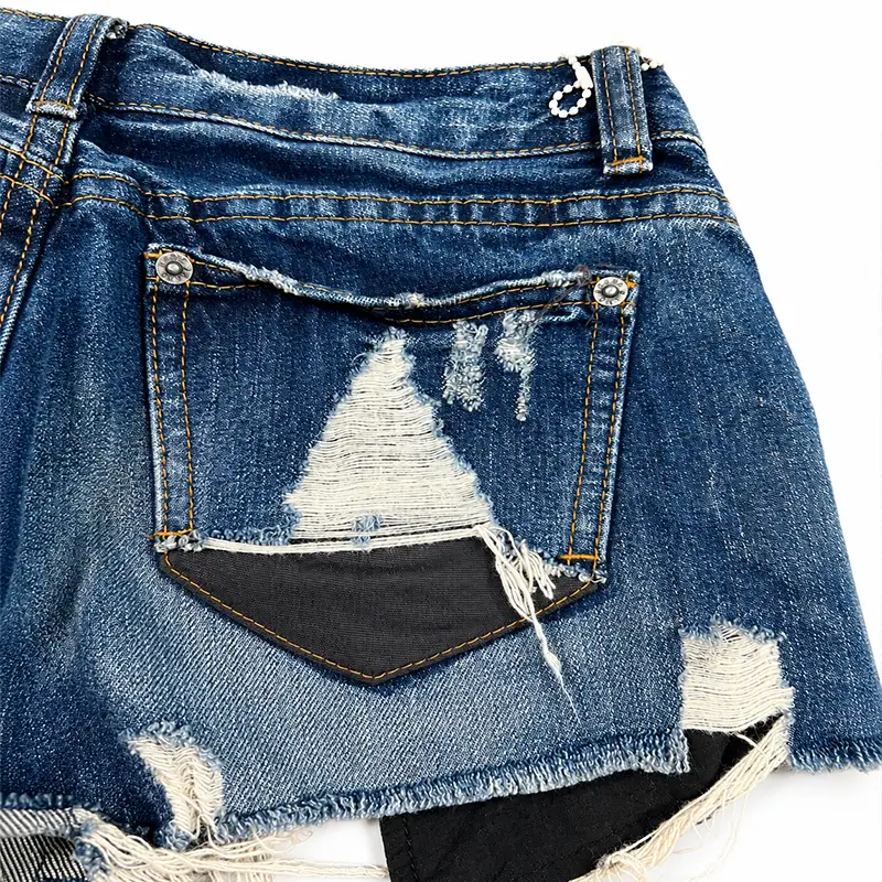 Side pocket detail of custom distressed denim shorts with dark wash denim and ripped details