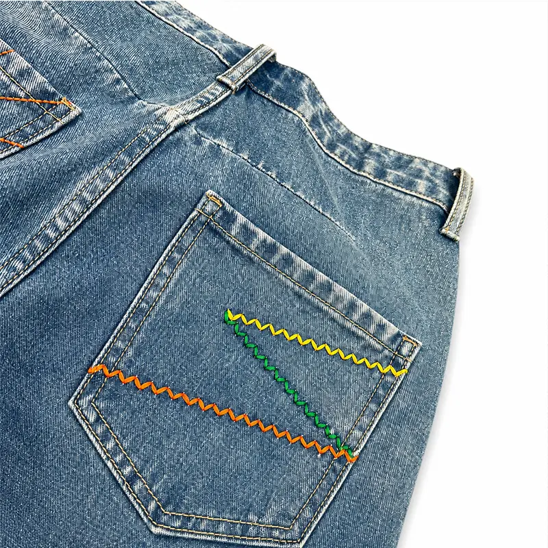 Back pocket detail of custom denim jeans with colorful zigzag stitching for private label brands
