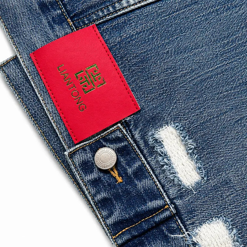 Custom red leather brand patch on distressed denim jacket